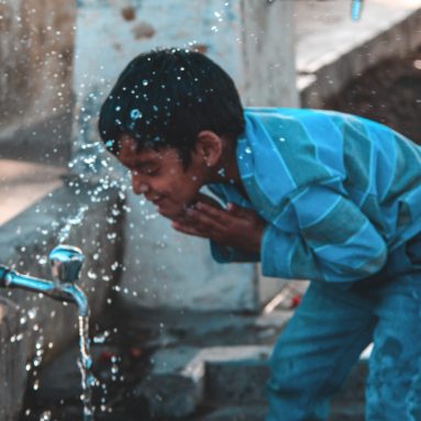 boy-standing-in-front-of-faucet-1469874