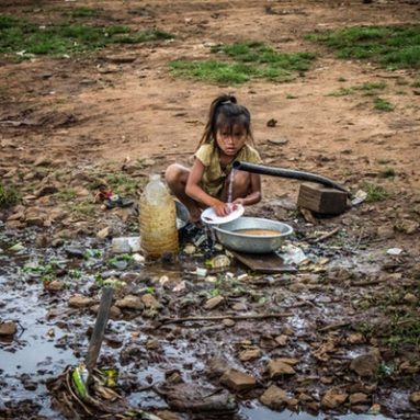 girl-washing-dishes-outdoors-front-of-hose-1232750